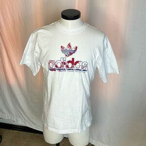 White mens adidas shirt with blue and red trefoil design logo